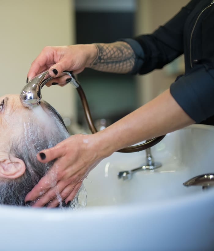 A client having their hair washed at a salon basin