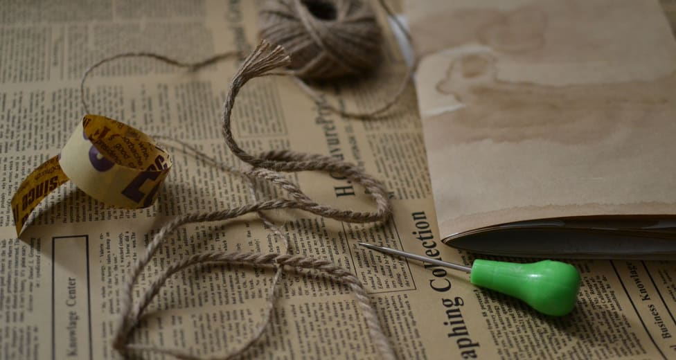 Twine, brown paper and newspaper laid out on a workbench